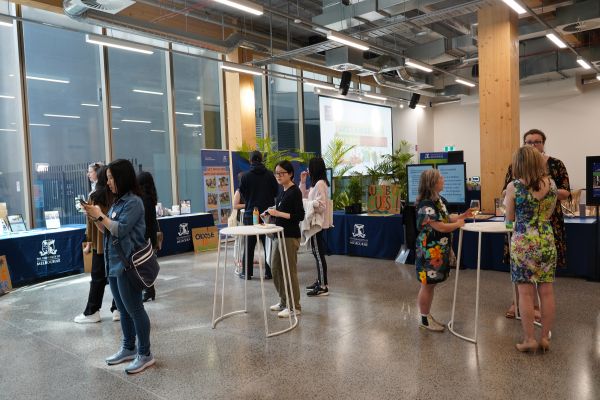 An image of the attendees of the 2022 ceremony mingling, with many tables arranged about with information about different sustainability programs.