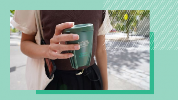 Person holding a reusable coffee cup