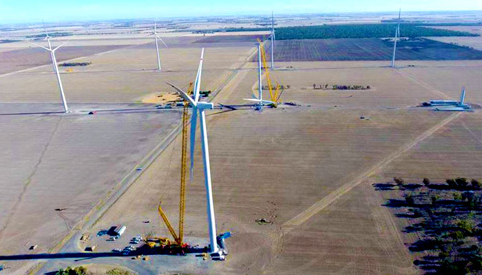 Photo from the air of a wind turbine being constructed on a windfarm with six other turbines being built in the background